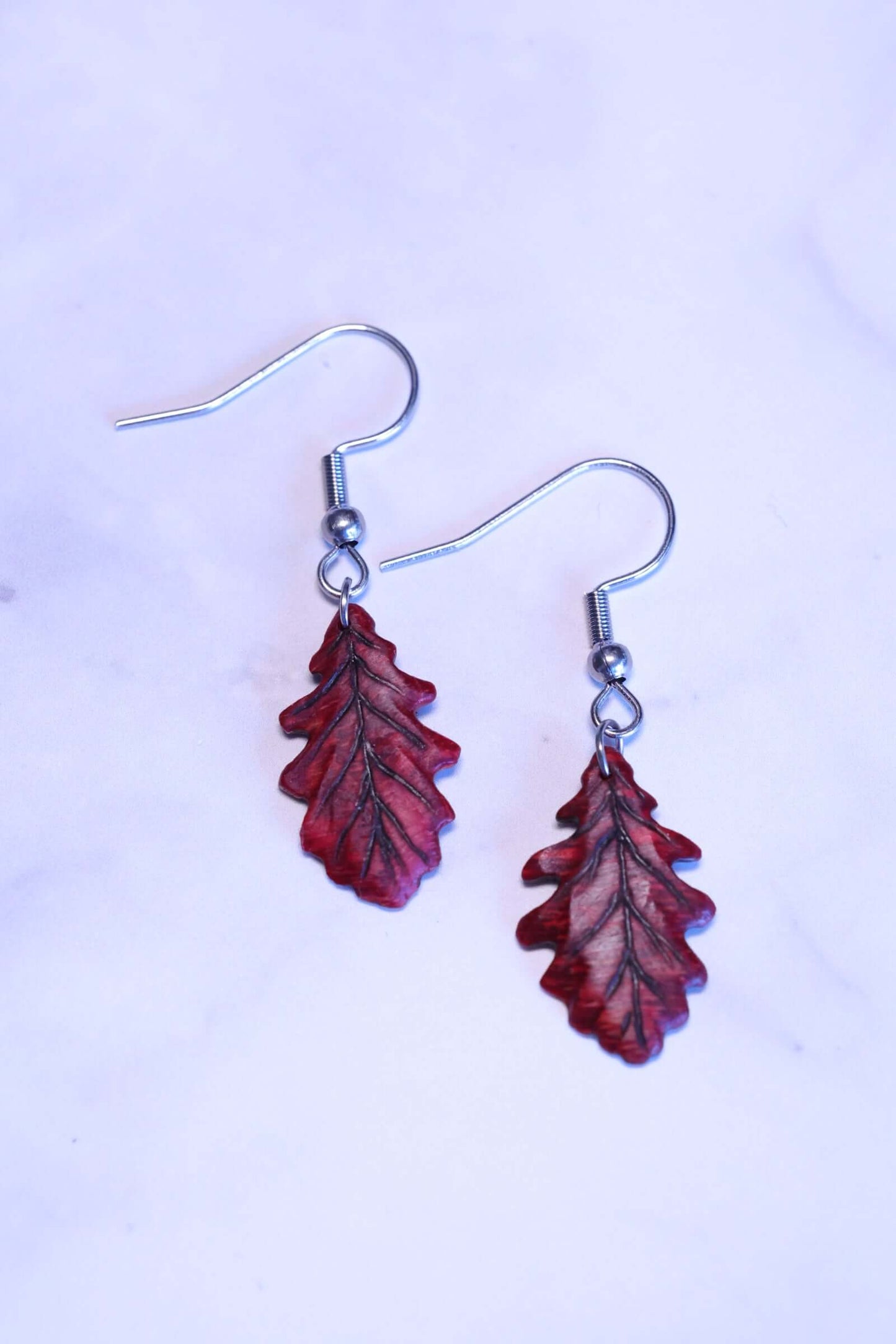 Holzohrringe - Eichenblätter aus robustem Holz mit leuchtenden Farben und Edelstahl-Haken, elegant und modern.