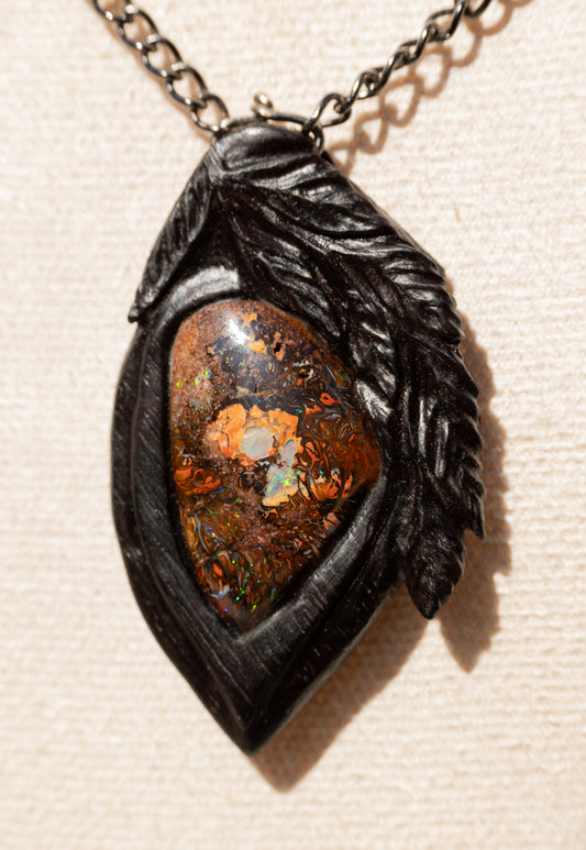 Naturwunder: Leuchtender Boulderopal, geborgen in Indischem Palisander