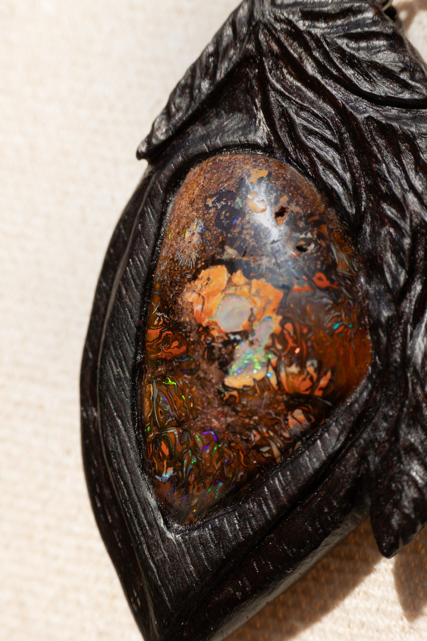 Naturwunder: Leuchtender Boulderopal, geborgen in Indischem Palisander