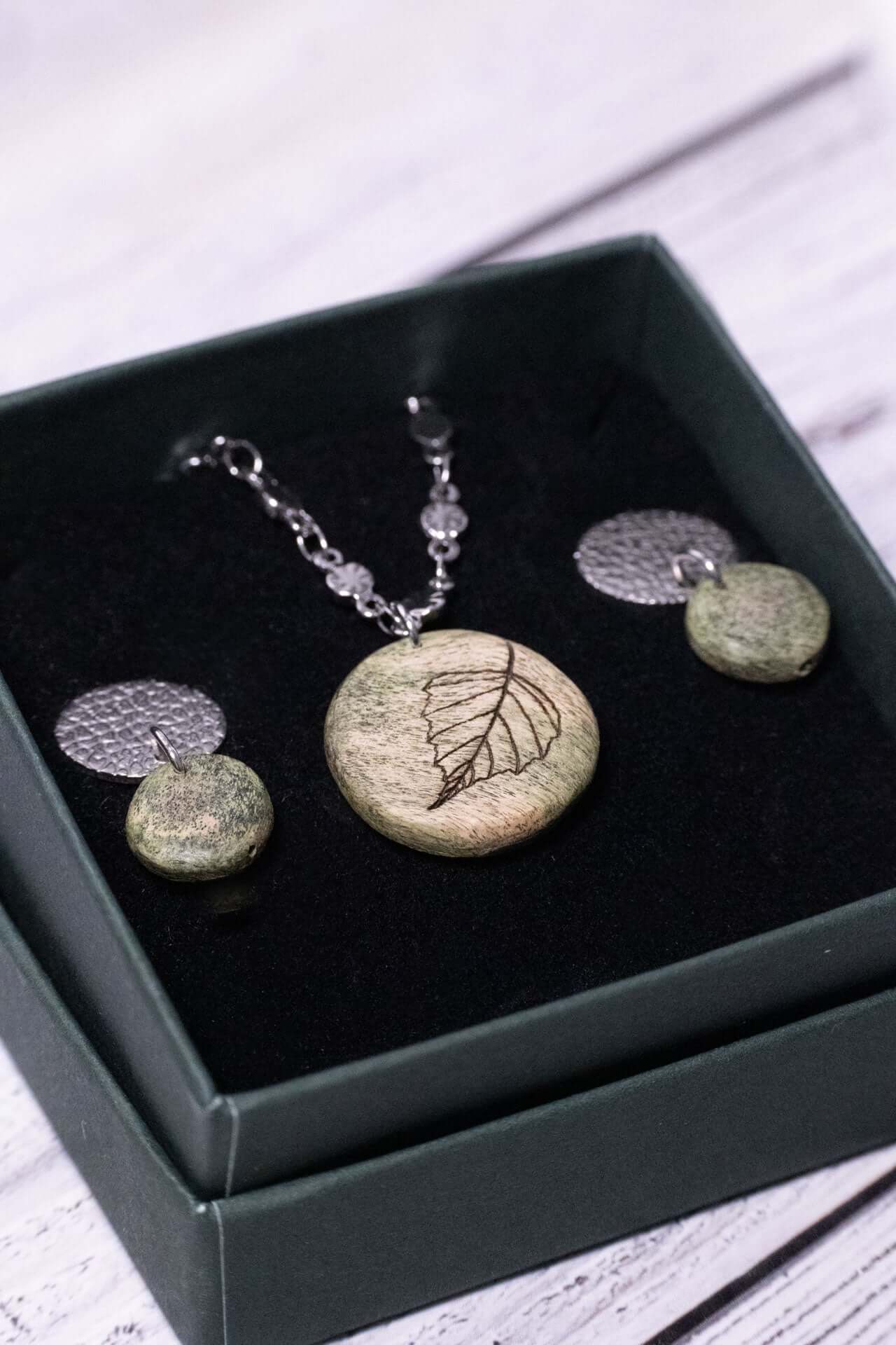 Elegantes Holzschmuckset "Frühlingserwachen" mit feiner Lasergravur und modernem Design in zarten Grüntönen.